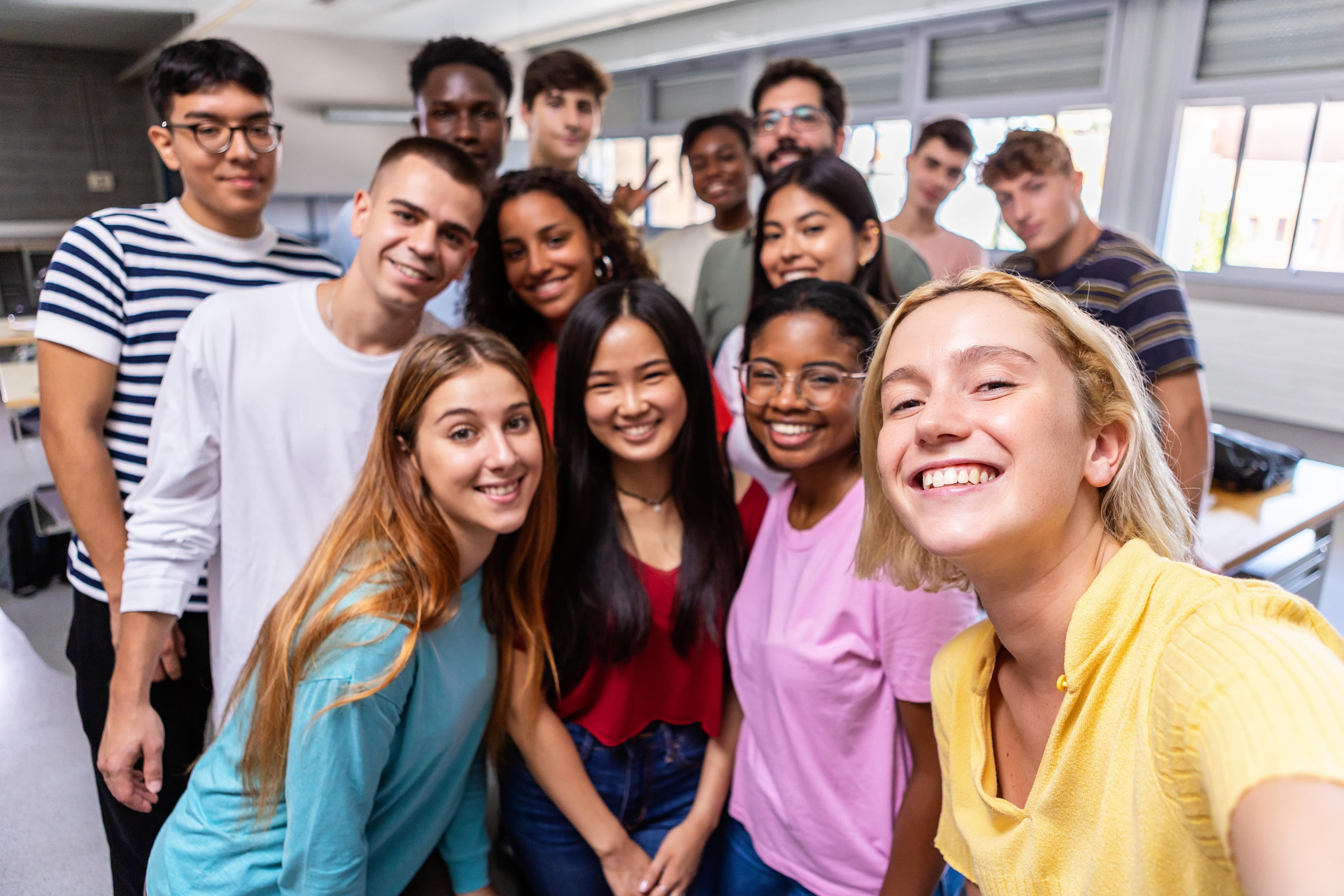 Plusieurs étudiantes et étudiantes sourient en prenant un selfie