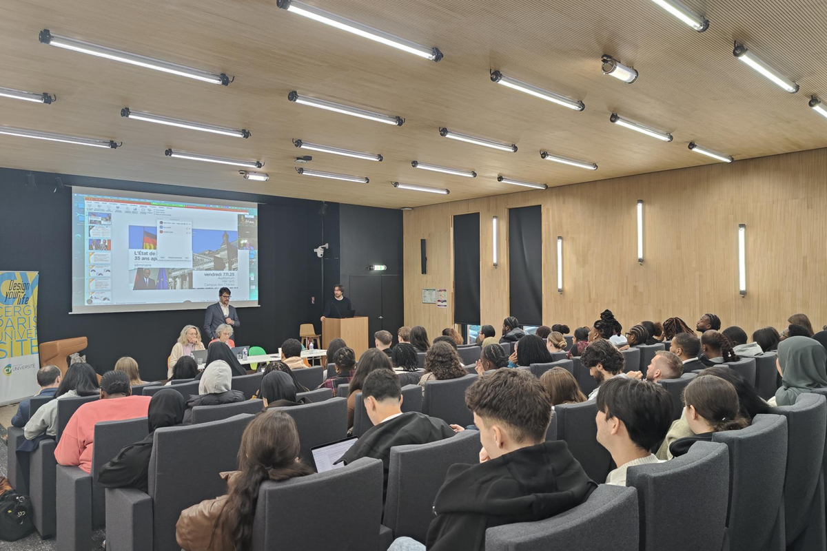 L'auditorium est comble, des étudiantes et des étudiants écoutent attentivement la présentation