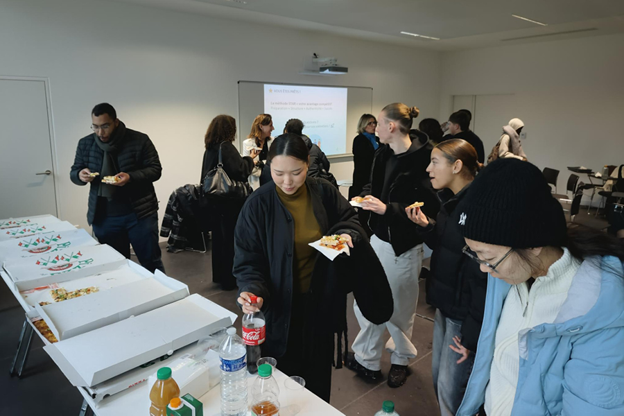 des étudiantes et des étudiants sont en train de se servir des parts de pizza et des sodas avant de débuter leur atelier